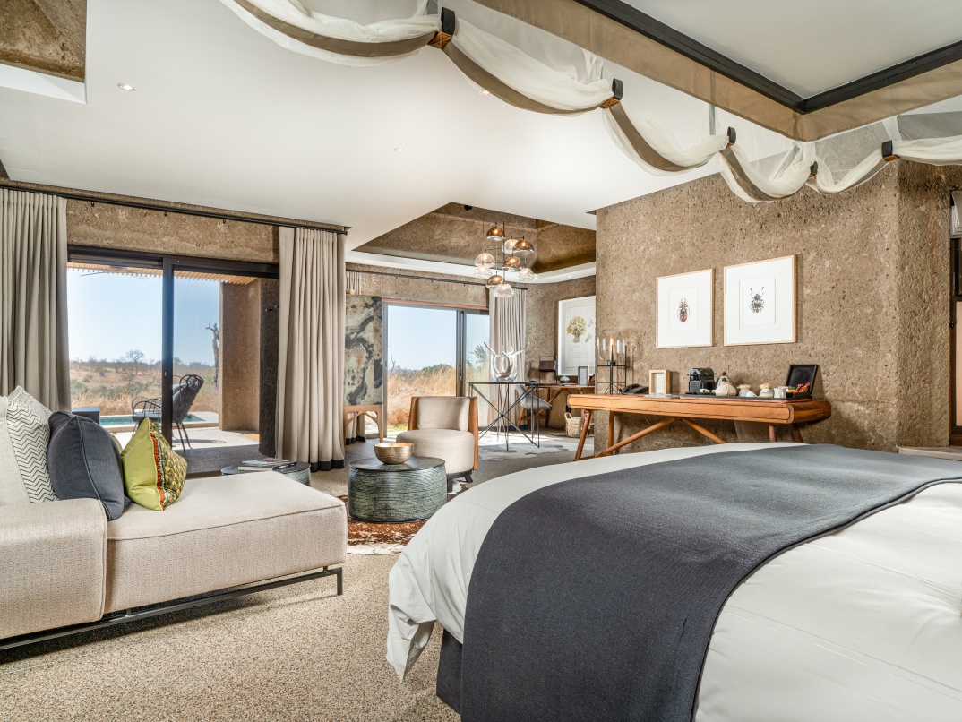 Experience the seamless integration of a spacious bedroom with the natural surroundings in Earth Lodge's Luxury Suite. Experience the seamless integration of a spacious bedroom with the natural surroundings in Earth Lodge's Luxury Suite.